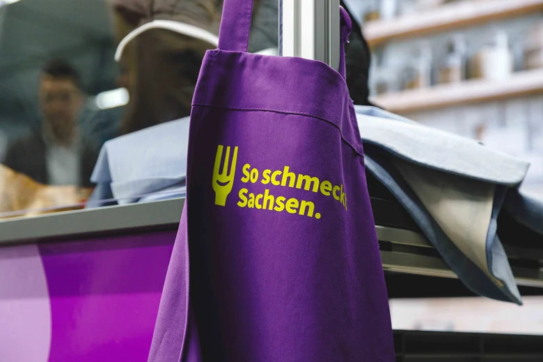 Lila Schürze mit Gabel und Slogan